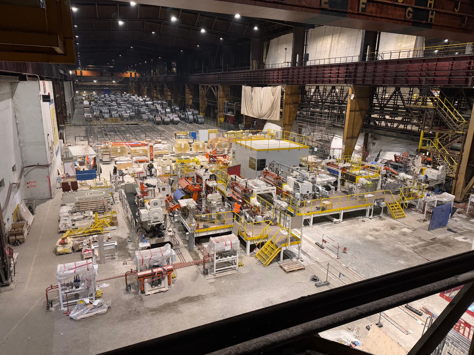 Vue plongeante d’une ligne de production en cours de montage dans une grande halle industrielle