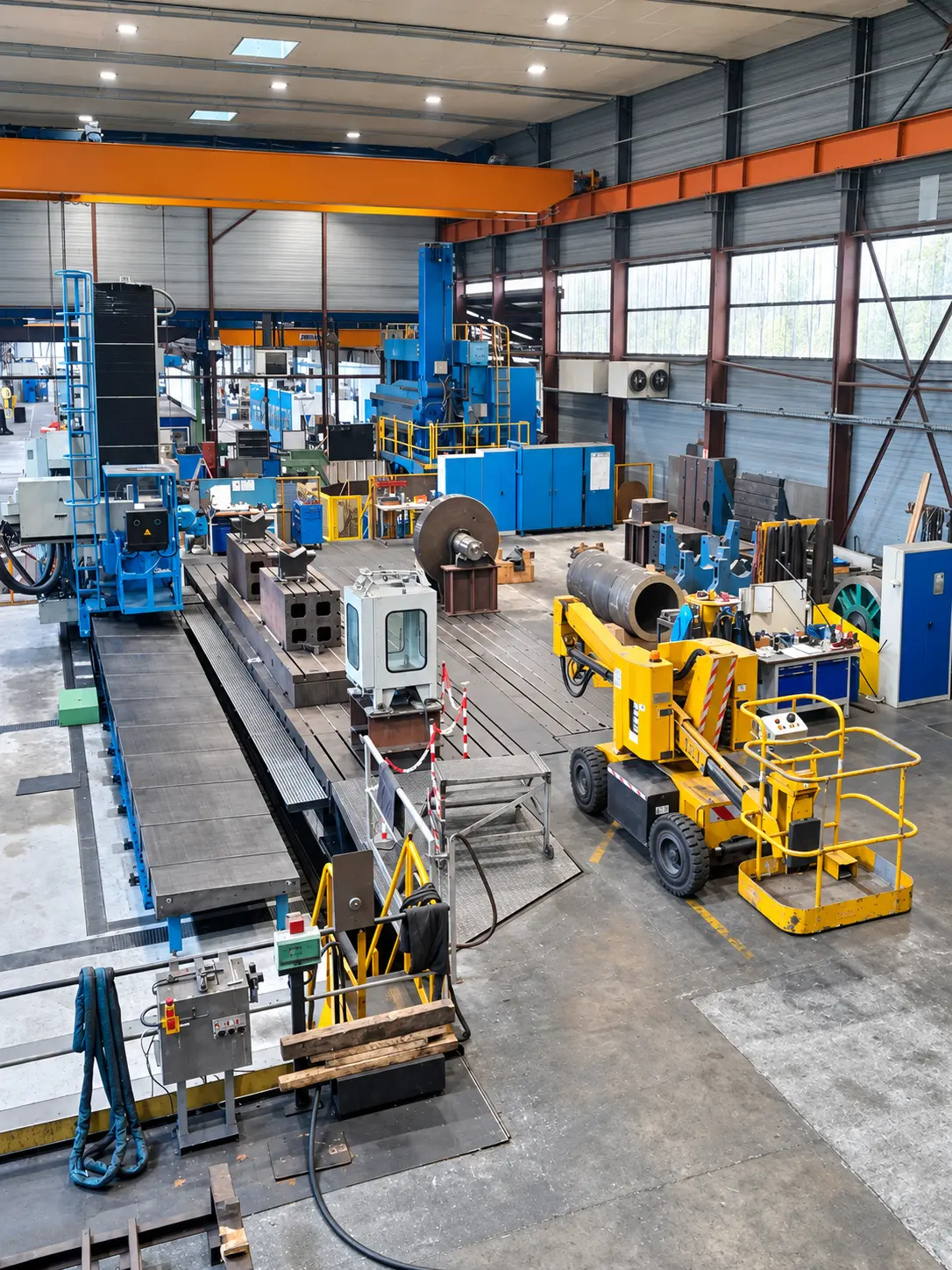 Vue en hauteur de l'atelier Allioss : pont roulant orange et machines d'usinage bleues