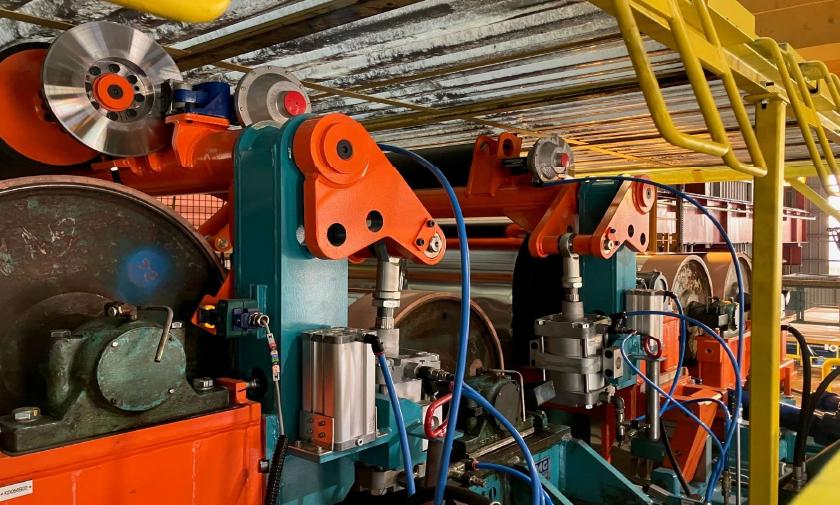 Cylindres orienteurs orange et bleus installés sur une ligne de production
